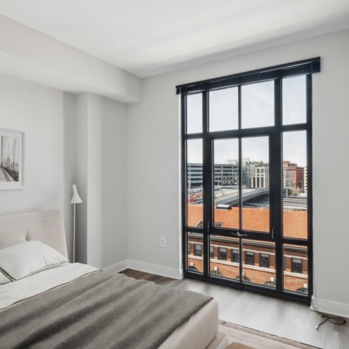 a bedroom with a bed and a large window