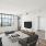 a living room with a tv, a couch and chairs