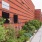 a brick building with plants and a sign on the side